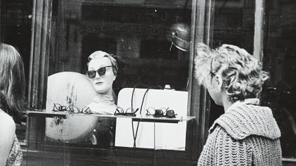 black & white phot of women looking through a shop window